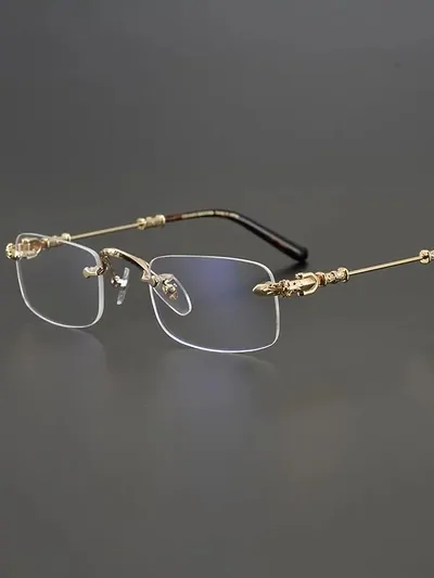 Rimless rectangular glasses with slim gold temples on a grey background