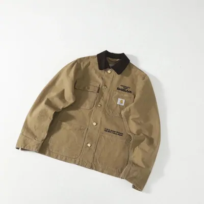 Tan canvas chore jacket with dark corduroy collar, laid flat